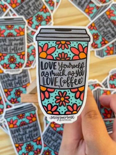 Coffee cup shaped vinyl sticker with orange flowers light blue background that says love yourself as much as you love coffee in a hand lettered script